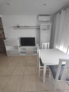 a living room with a white table and a tv at Vinaros Modern Apartment in Vinarós +5 photos