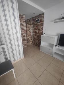 a living room with a tiled floor and a brick wall at Vinaros Modern Apartment in Vinarós