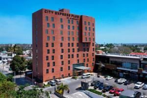 a tall red brick building with a city exchange place sign on it at City Express Plus by Marriott Tampico in Tampico