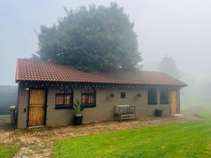 a small house with a tree on top of it at Origin Cottage in eMalahleni