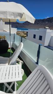 a pair of chairs and an umbrella on a patio at Casa Naya in Famara