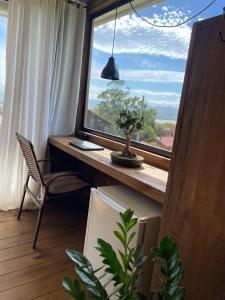 a window with a desk and a chair in a room at Suítes Âncora Praia do Rosa in Imbituba