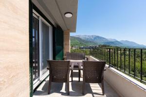 a balcony with two chairs and a table with a view at Stars Apartments in Tivat