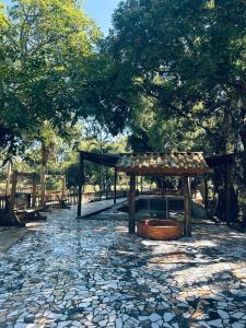 a pavilion in a park with trees and a stone path at Pousada Maria elza in Eldorado