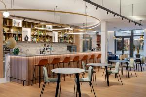 a restaurant with tables and chairs and a bar at Courtyard by Marriott Biel Bienne in Biel