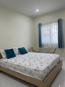a bedroom with a bed with chairs and a glass table at 529 Cozy rooms in Ban Si Than