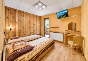 a bedroom with a bed and a tv on the wall at Pod Smerkami in Szklarska Poręba