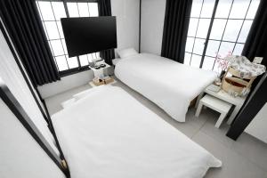 a small room with two beds and a tv at 紡ぎの宿 桜 - 民泊 - Tsumugi no Yado SAKURA in Abiko +67 photos