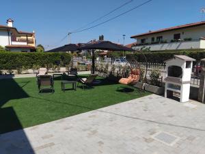 a patio with a table and chairs and an umbrella at La Tavernetta delle Terme Euganee in Montegrotto Terme
