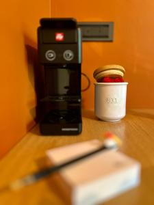 a coffee maker with a cup and a pen on a table at Feel B&B and more in Saluzzo