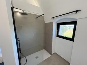 a bathroom with a shower with a window at Giù al Vigneto in Leporano