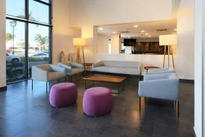 a living room with pink and blue chairs and tables at City Express by Marriott Tampico in Tampico