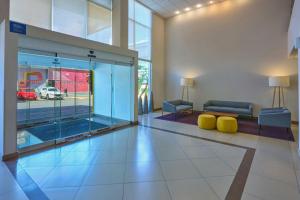 a lobby with a couch and a glass door at City Express by Marriott San Luis Potosi Zona Universitaria in San Luis Potosí