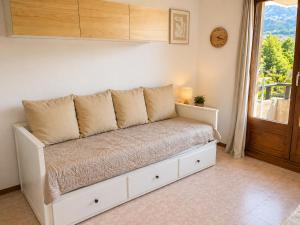 a white bench in a room with a window at Vue montagne exceptionnelle T2 Cosy avec Balcon proche du lac in Embrun