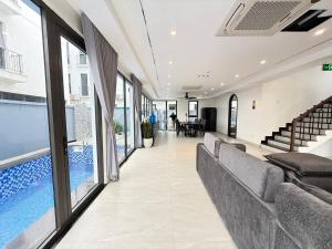 a living room with couches and a swimming pool at Villa Florent in Thanh Hóa