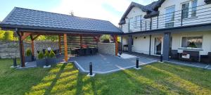 a house with a covered patio in the yard at Na Jurze in Mirów +1 photo