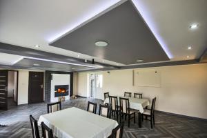 a dining room with tables and chairs and a fireplace at Na Jurze in Mirów