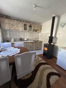 a kitchen with a wooden table and a stove at Guesthouse Idea in Vusanje