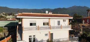 a white house with a balcony with mountains in the background at Casa Las Laderitas A in El Paso