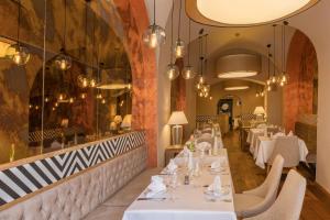 a dining room with white tables and chairs at Apartment Promenáda 35 in Karlovy Vary