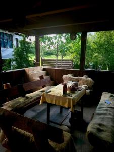 a screened in porch with a table and benches at Cabana Drumetului Borzesti in Borzeşti