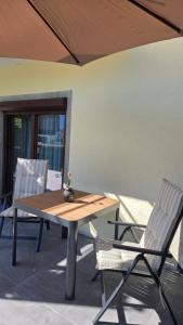 a wooden table and two chairs on a patio at Appartement Demelfischer am See in Altmünster