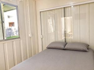 a bed in a room with a window at Condominio Vila Contanainer in Morretes