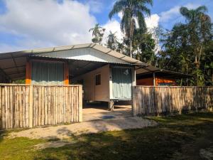 a house with a wooden fence in front of it at Condominio Vila Contanainer in Morretes