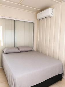 a bedroom with a bed and a air conditioner at Condominio Vila Contanainer in Morretes +15 photos