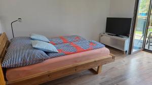 a bed with pillows and a television in a room at Appartement Demelfischer am See in Altmünster