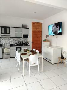 a kitchen with a white table and white chairs at Los Pulpos Beach House in Bombiso