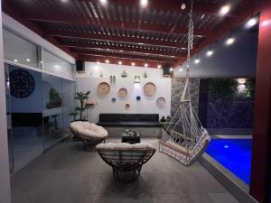 a living room with a swing and a swimming pool at Los Pulpos Beach House in Bombiso
