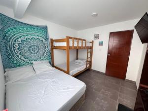 a small room with a bed and a bunk bed at Los Pulpos Beach House in Bombiso +29 photos