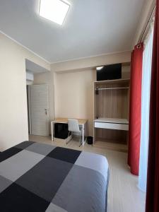 a bedroom with a bed and a desk with a chair at B&B Bagnara Vista Mare in Bagnara Calabra