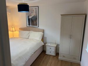 a bedroom with a bed and a picture on the wall at The Bat Barn in Corsley