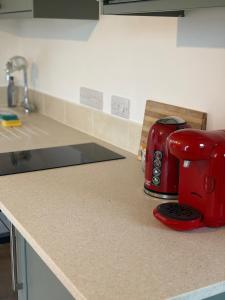 a red toaster sitting on a counter in a kitchen at The Bat Barn in Corsley