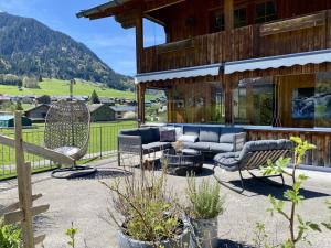 a house with a patio with furniture and mountains in the background at Rüf Stefanie in Au im Bregenzerwald