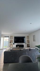 a living room with a large couch and a flat screen tv at Chez TIKA in Saint-Lager