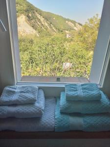 a bathroom with a window with three blue towels at Casina Borgo Castello in Civitella di Romagna +17 photos