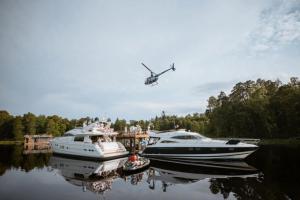 a helicopter flying over two boats in the water at The Lux Yachts - Luxury Private Yacht Experience in Helsinki +4 photos