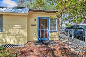 a small yellow house with a blue door at Downtown Gem- Dog Friendly Walk to Everything in St. Augustine