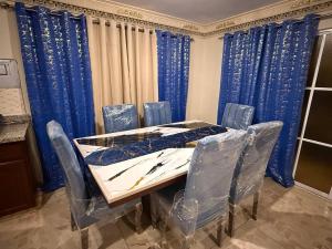 a dining room with a table and blue curtains at Segundo Piso complet in La Cuaba