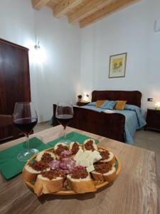 a plate of food and two glasses of wine on a table at Borghetto Meti in Avola