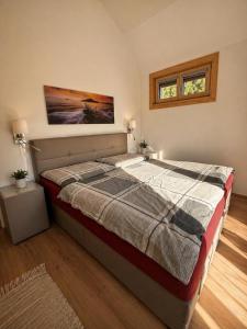 a large bed in a bedroom with two windows at Chalet am Sonnberg in Kleinlobming