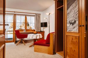 a room with a table and two chairs and a desk at Bergblick - der Gasthof in Riezlern
