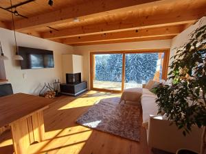 a living room with a couch and a large window at Der Distelfalter in Oberhaag