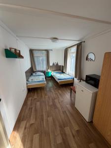 a room with two beds and a wooden floor at Chaty Kašperské Hory in Kašperské Hory
