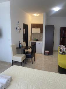 a room with a table and chairs and a kitchen at Apartments Delfin in Bar