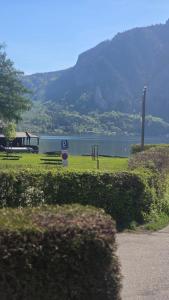 a park with a lake and mountains in the background at Appartement Demelfischer am See in Altmünster +45 photos