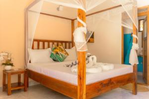a bedroom with a canopy bed with stuffed animals on it at Sunset Mkuu Boutique Hotel in Michamvi +104 photos